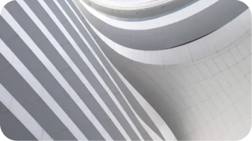 Gros plan sur une façade architecturale blanche aux lignes courbes et rayures géométriques, jeu d'ombre et lumière