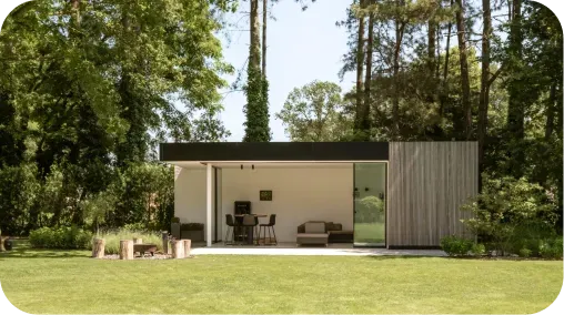 Pavillon de jardin moderne au toit plat noir avec bardage bois, entouré d'une pelouse et d'arbres