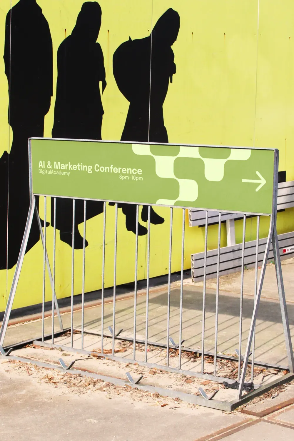Panneau de signalétique "AI & Marketing Conference" Digital Academy, installé devant un mur jaune avec silhouettes noires