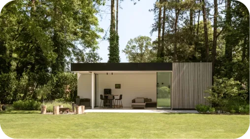 Pavillon de jardin moderne au toit plat noir avec bardage bois, entouré d'une pelouse et d'arbres