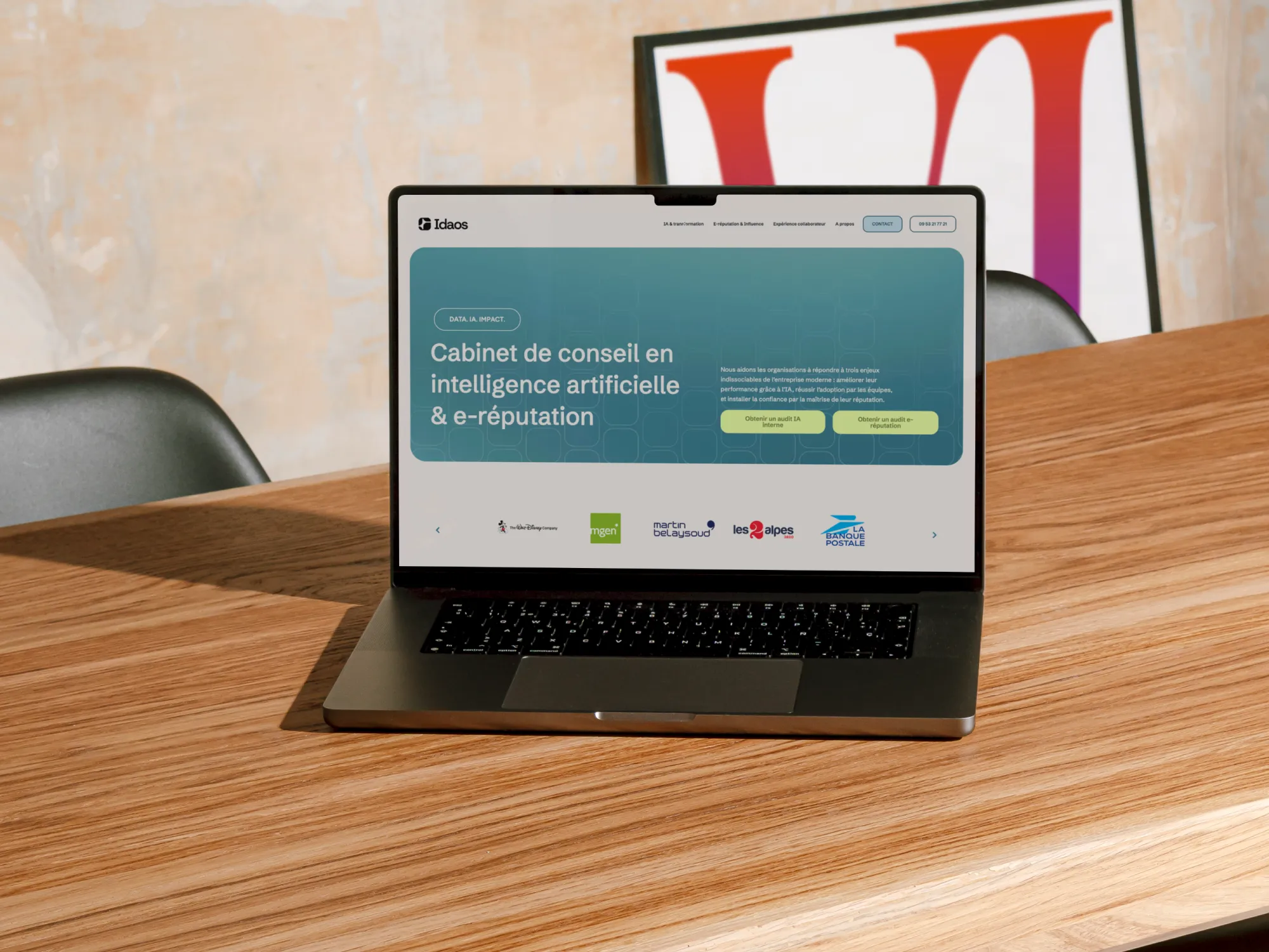 Ordinateur portable sur table en bois affichant la page d'accueil du site Idaos, cabinet de conseil en intelligence artificielle et e-réputation