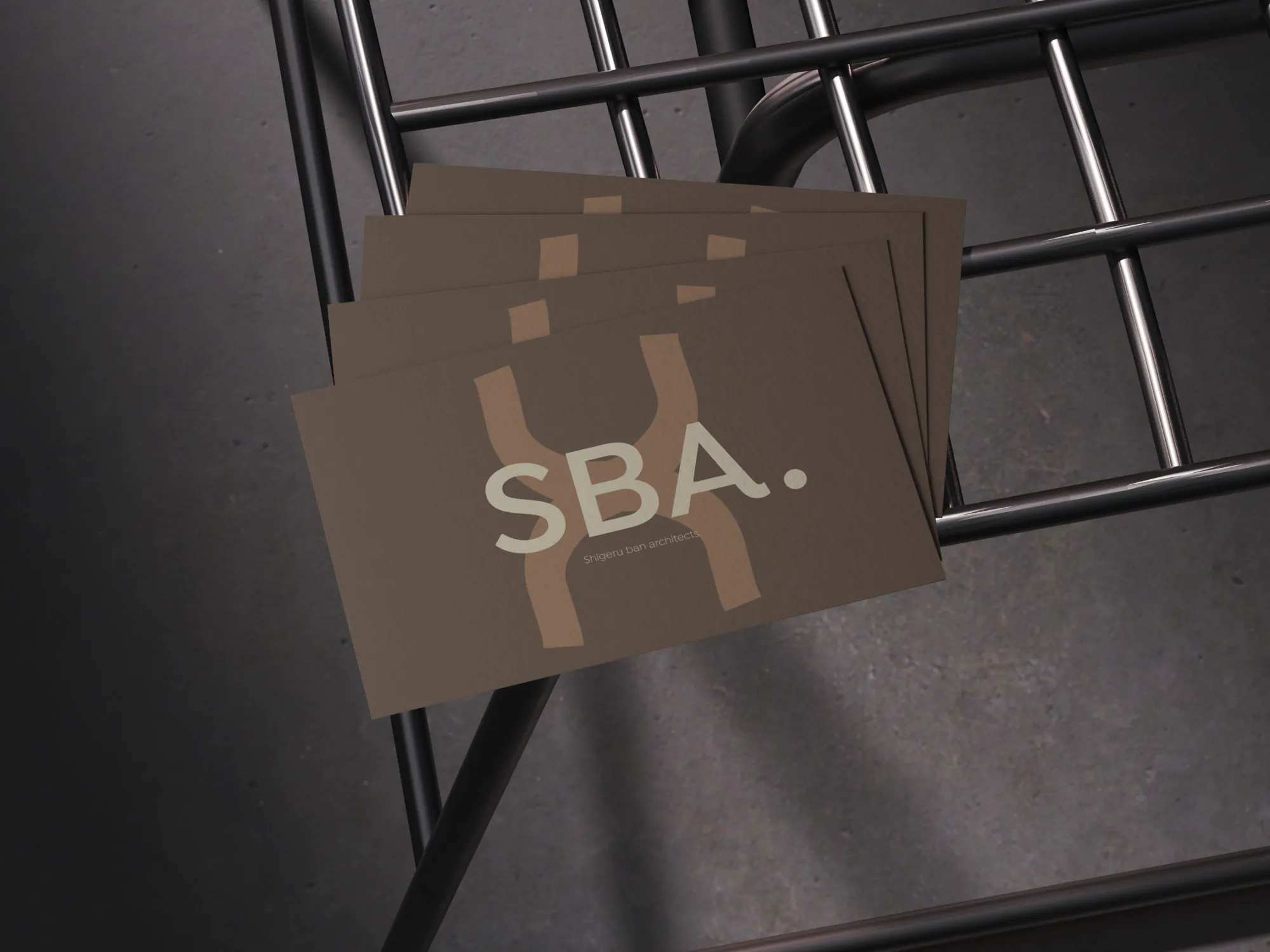 Cartes de visite marron avec logo "SBA." posées sur une structure métallique noire