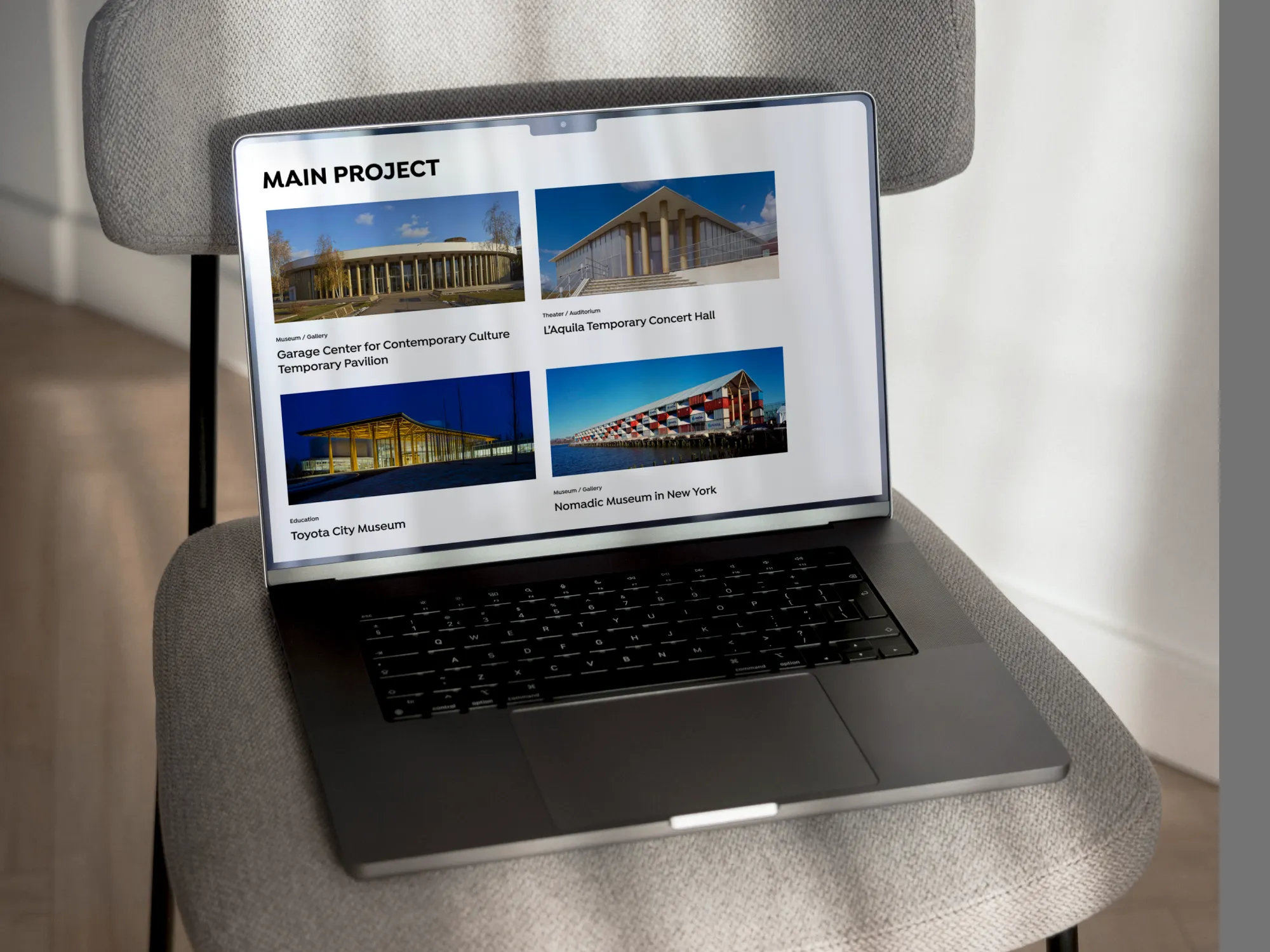 Ordinateur portable posé sur un fauteuil affichant la page "Main Project" du site SBA avec quatre projets architecturaux